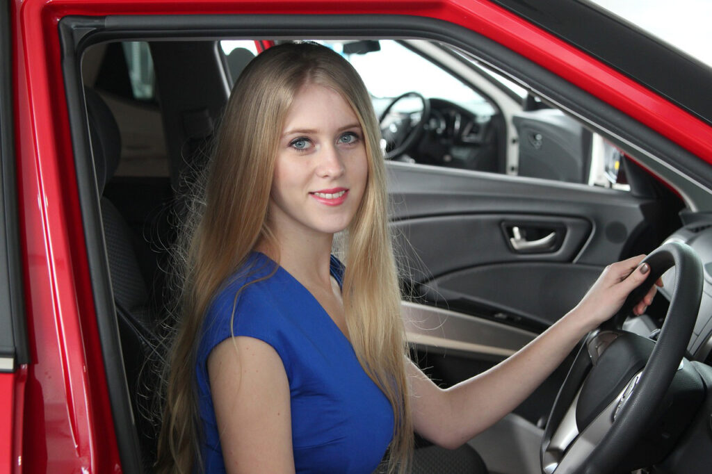Young woman behind the steering wheel of a car.